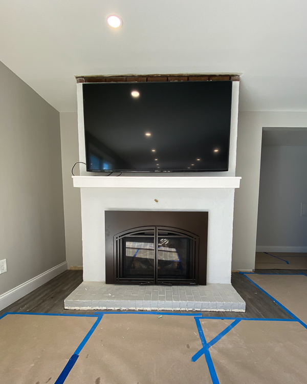 An outdated painted brick fireplace