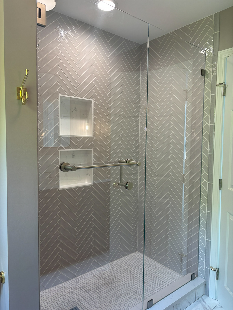 Herringbone tiled shower in an Orchard Park bathroom