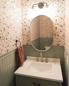 green bathroom paneling with floral wallpaper